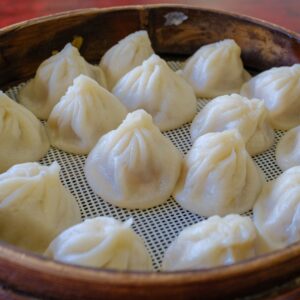 Freshly steamed xinolongbao dumplings in a bamboo steamer, showcasing traditional Chinese cuisine.