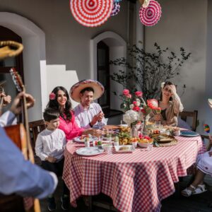 A vibrant family gathering celebrating with traditional Mexican decor and attire.